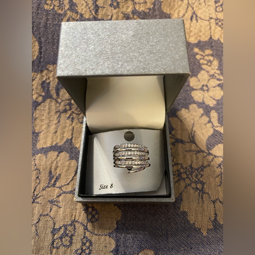 New Directions ring. New in box. Silver finish with white stones. Size 8.